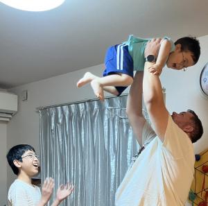 ホストファミリーのお子さんをたかいたかいをする団員