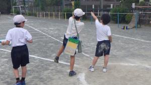 高学年が低学年にソフトボール投げを教えている写真